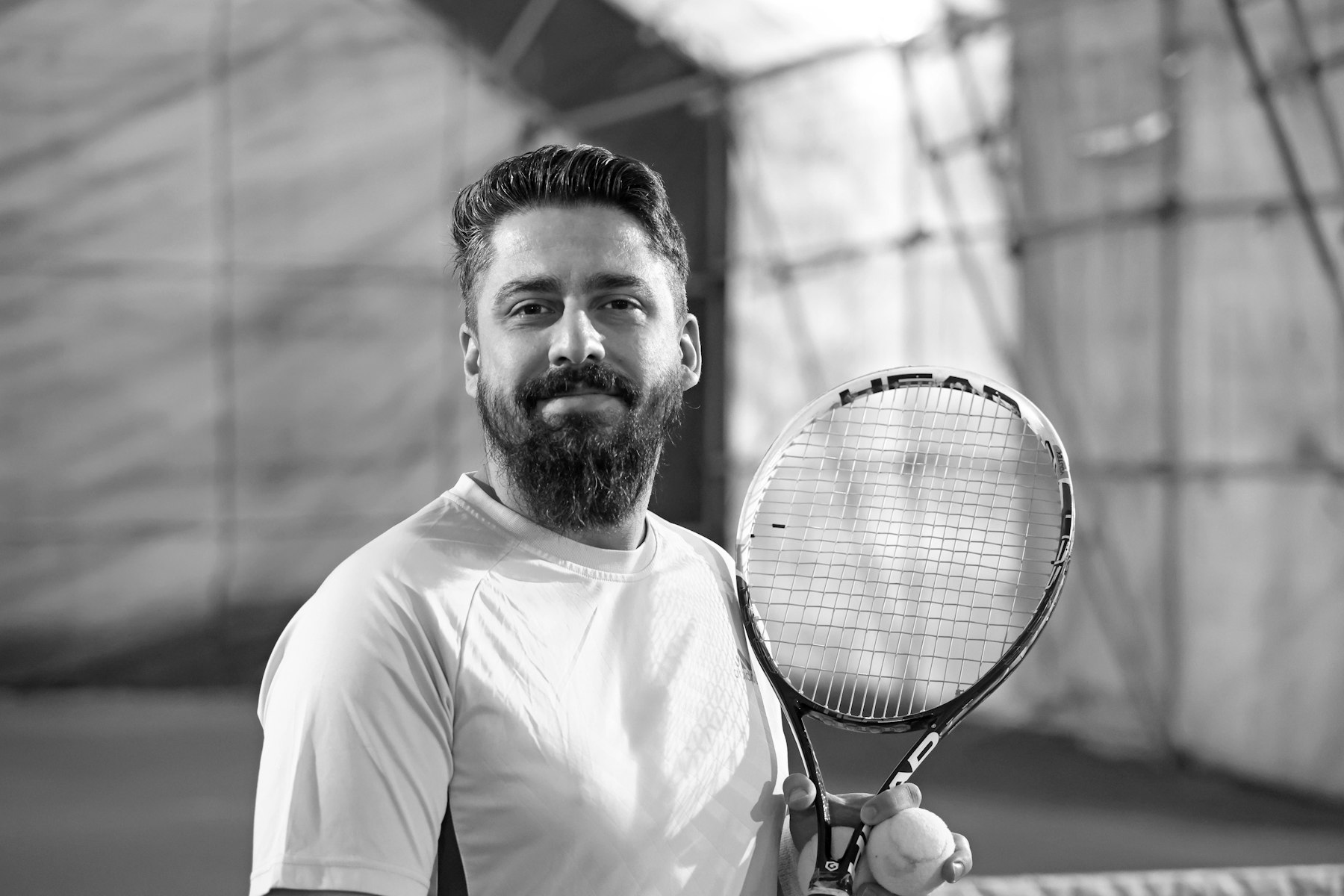 Coach holding racket and ball before a session