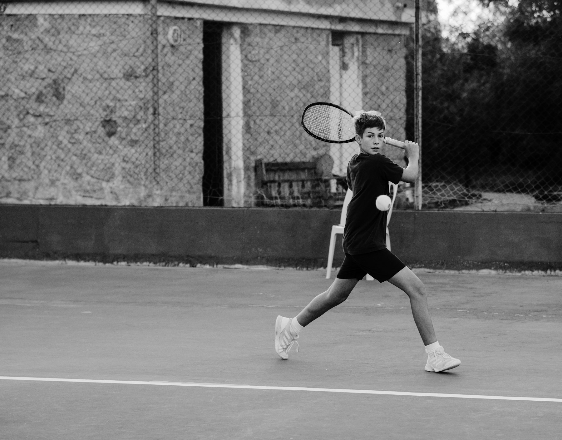 Player driving through a forehand on an outdoor court