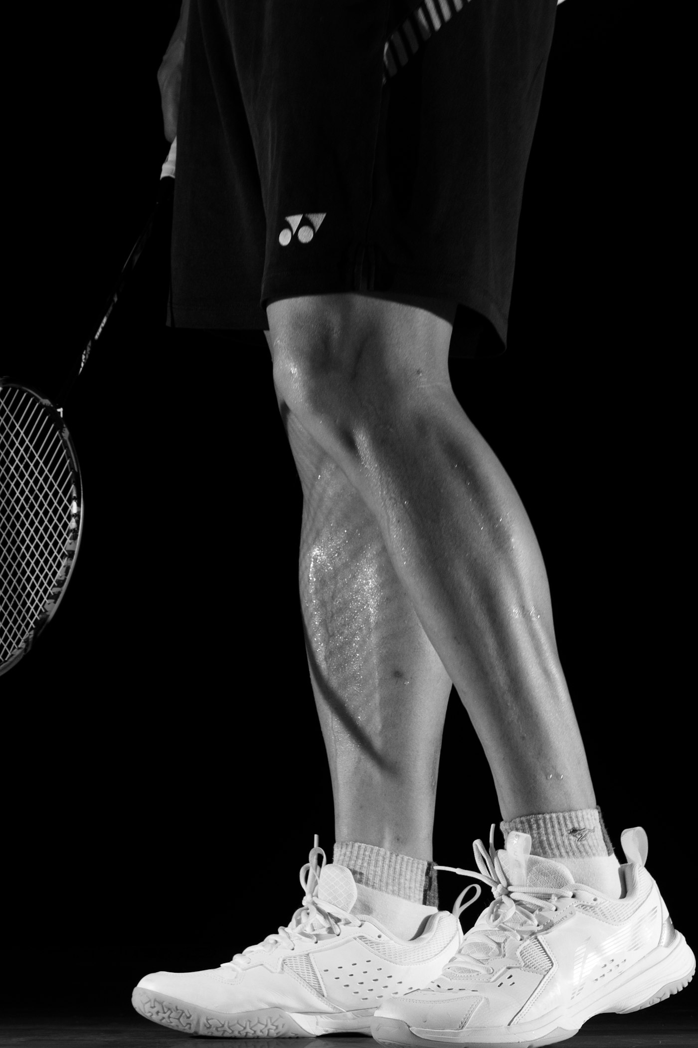 Close technical detail of legs and racket under tension